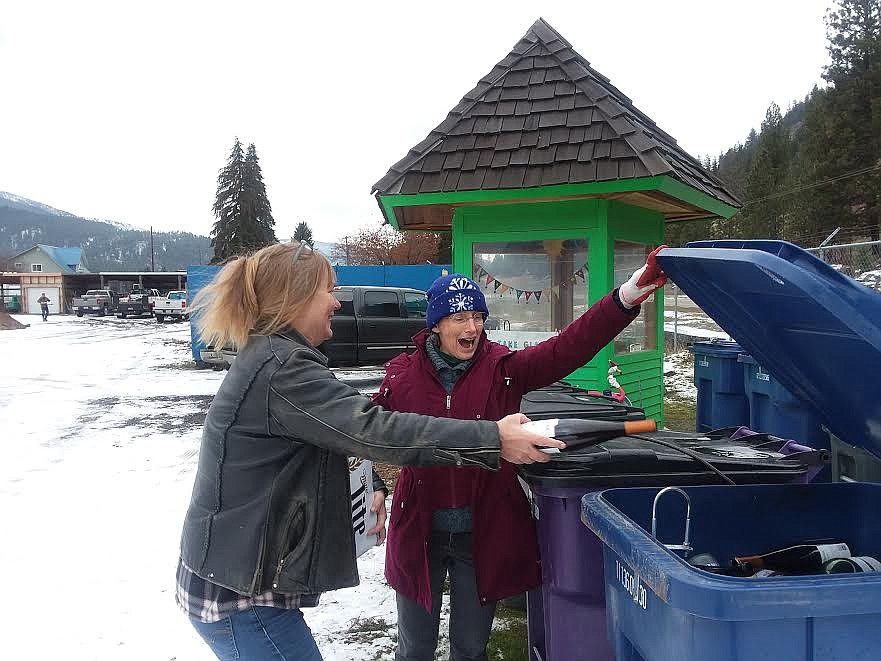 Superior recycling coordinator Emily Ornelas, right, laughs with Dianne Hill as she deposits bottles in the new glass recycling bin. (Monte Turner/Mineral Independent)