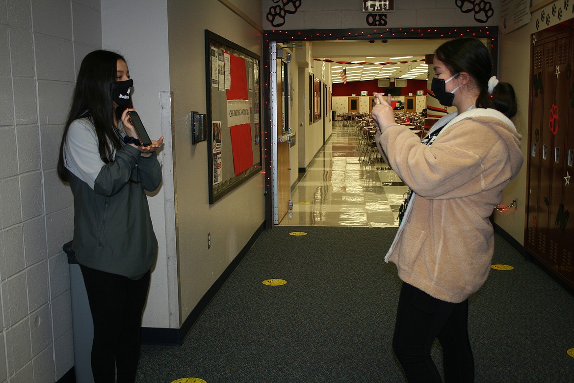 Cindy Magana (right) explains new daily check-in rules for Othello High School students, with her sister Elidia doing the filming. The school's ASB officers were asked to film a video detailing the rules for students prior to the reopening of OHS Jan. 25.