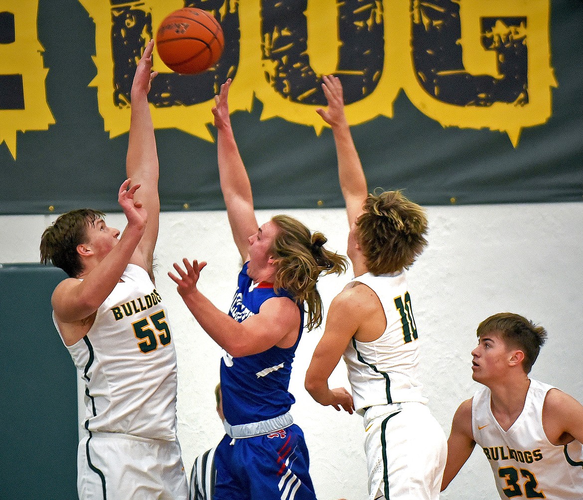 Bulldog Talon Holmquist goes up for a block against Columbia Falls guard Cade Morgan on Thursday. (Whitney England/Whitefish Pilot)