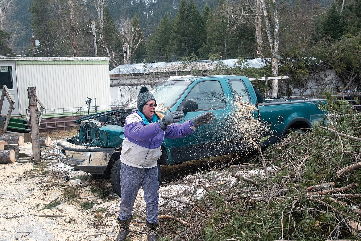 Doreen Seymour traveled up from Butte to clean up their Hungry Horse rental properties, which had numerous trees down om and around their trailers. (Chris Peterson photo)