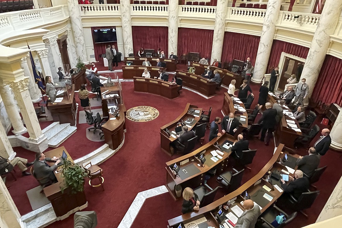 In this Friday, Jan. 15, 2021, file photo, the Idaho Senate gathers in the Statehouse in Boise, Idaho. Lawmakers in the Idaho Senate have been told to monitor their health after a Senate staffer tested positive for COVID-19, but the Senate will continue operating. Senate President Pro-Tem Chuck Winder said Tuesday, Jan. 19, 2021, that the staffer was infected by a family member outside the Statehouse and went to work Friday with no symptoms.