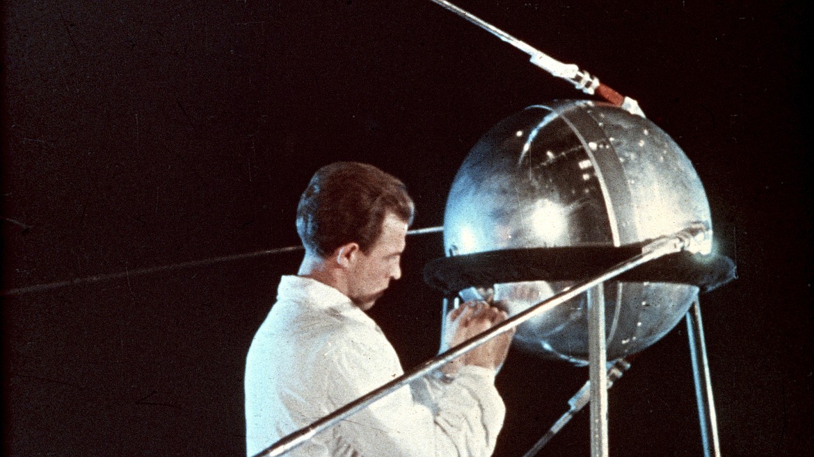 Soviet space scientist with Sputnik 1 before the launch in 1957, with the U.S. sending Explorer I into space just three months later, never again relinquishing the space race to the Russians.