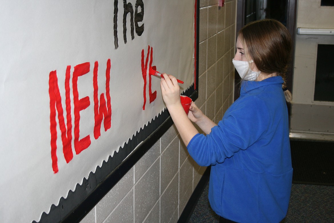 Kali Gomez paints a welcome back message on a bulletin board at Othello High School. Students return to OHS for part time instruction Jan. 25, for the first time since March.