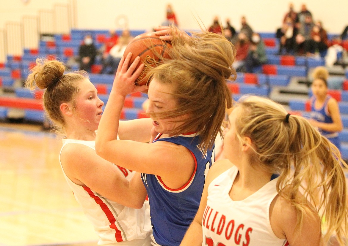 JASON ELLIOTT/Press
Coeur d'Alene senior Tori Younker chases down a rebound in between the defense of Sandpoint's Riley Cessna, left, and Destiny Lyons, right, during the second quarter of Thursday's game at Viking Court.