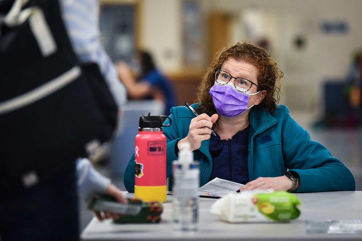 Amy Keith, a school health aide, checks in students as part of the COVID-19 screening process at Columbia Falls High School on Wednesday, Jan. 20. Keith and school nurse Angie Tamburelli were hired by the school for COVID-19 mitigation. (Casey Kreider/Daily Inter Lake)