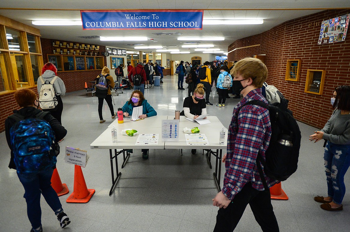 School health aide Amy Keith, left, and school nurse Angie Tamburelli check in students as part of the COVID-19 screening process at Columbia Falls High School on Wednesday, Jan. 20. (Casey Kreider/Daily Inter Lake)