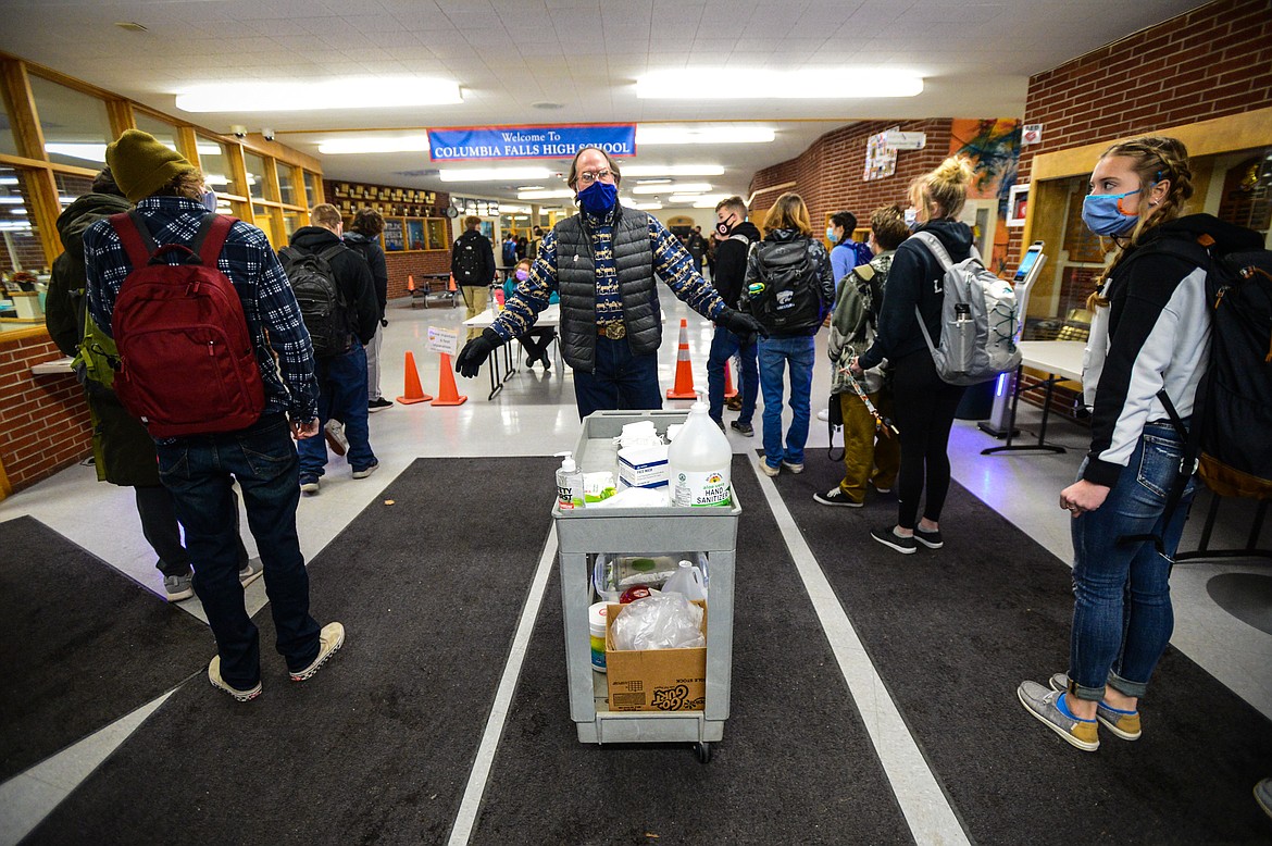 Michael Downey, a special education teacher, tells students to wear a mask and wear it properly while giving words of encouragement during the COVID-19 screening process at Columbia Falls High School on Wednesday, Jan. 20. (Casey Kreider/Daily Inter Lake)