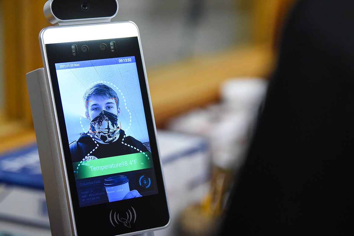 A student who agreed to be photographed uses a body temperature kiosk before the start of school at Columbia Falls High School on Wednesday, Jan. 20. (Casey Kreider/Daily Inter Lake)