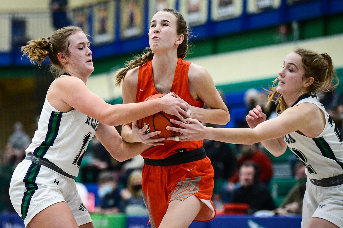 Glacier's Kenzie Williams (12) and Ellie Keller (22) defend against Flathead's Kennedy Moore (14), resulting in a jump ball, at Glacier High School on Friday. (Casey Kreider/Daily Inter Lake)