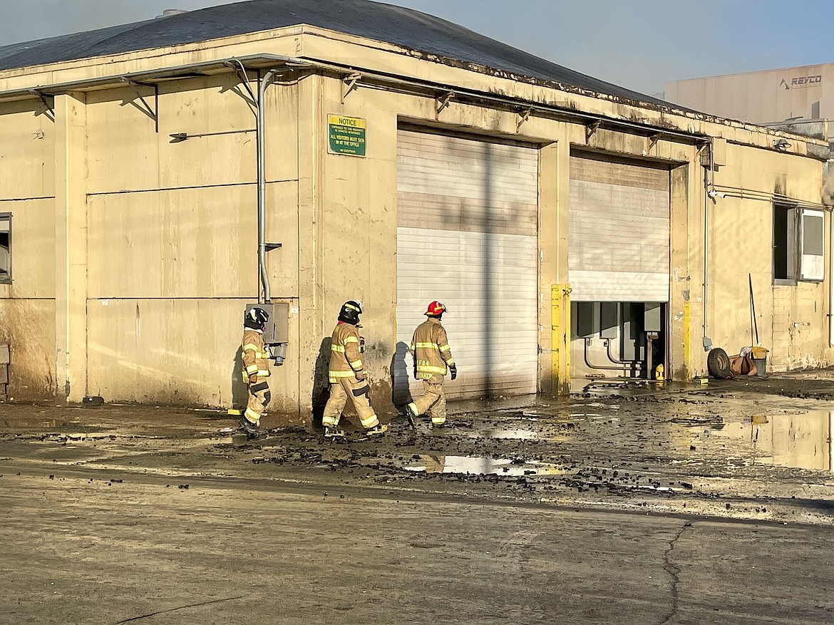 Firefighters with Grant County Fire District No. 4 in Warden walk around the Washington Potato Co. facility Friday morning after spending the night fighting a blaze which broke out in a potato dehydrator Thursday afternoon.