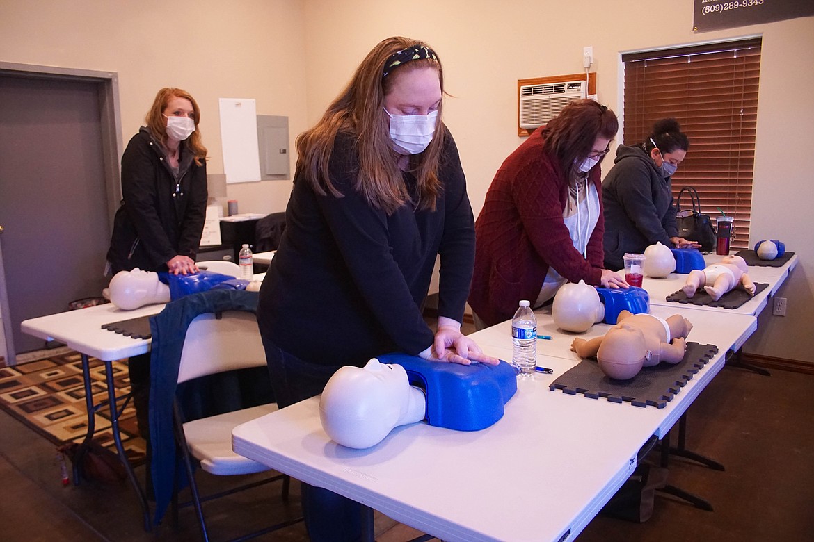 Laura Bruns (front), Joy Fondren (middle), Laura Nava (left) and Kiley Daniels (back) practice compressions at Heart Matters CPR & 1st Aid.