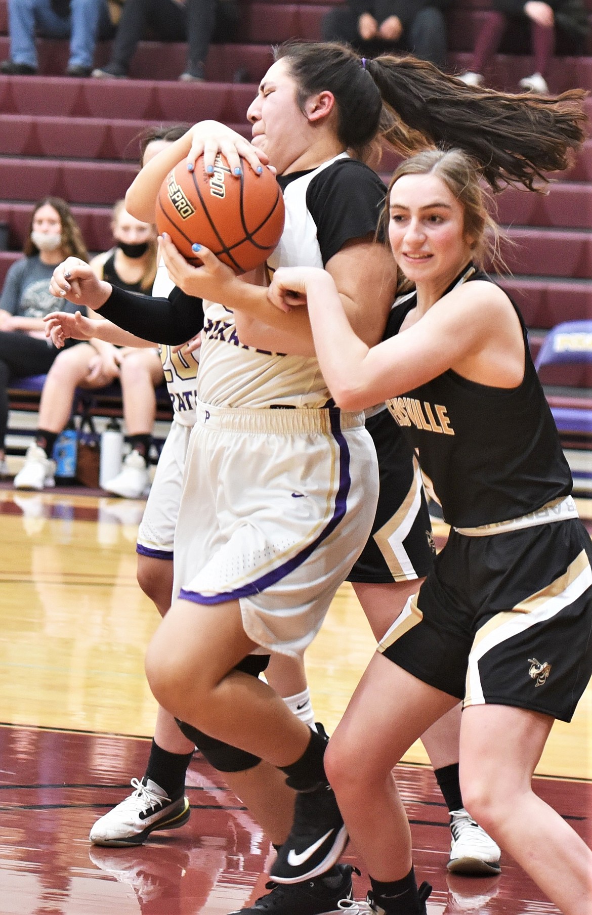 The Lady Pirates' Mossy Kauley pulls in a rebound next to Kelti Wandler (4). (Scot Heisel/Lake County Leader)