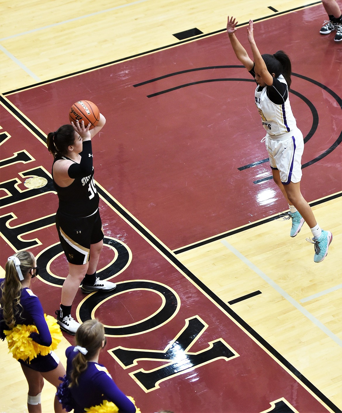 Turquoise Pierre gets some air while defending an inbound pass by Stevensville's Kennedy Praast. (Scot Heisel/Lake County Leader)