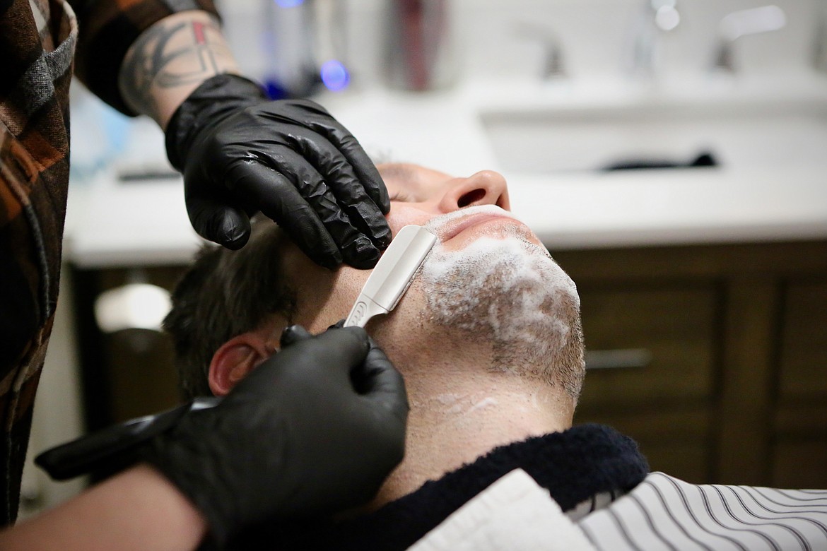 Markie Parks, owner of the new Swan Highway General Store & Barber Shop, shaves Mark Herman, a part-owner of Echo Lake Cafe on Thursday, Jan. 21.
Mackenzie Reiss/Bigfork Eagle