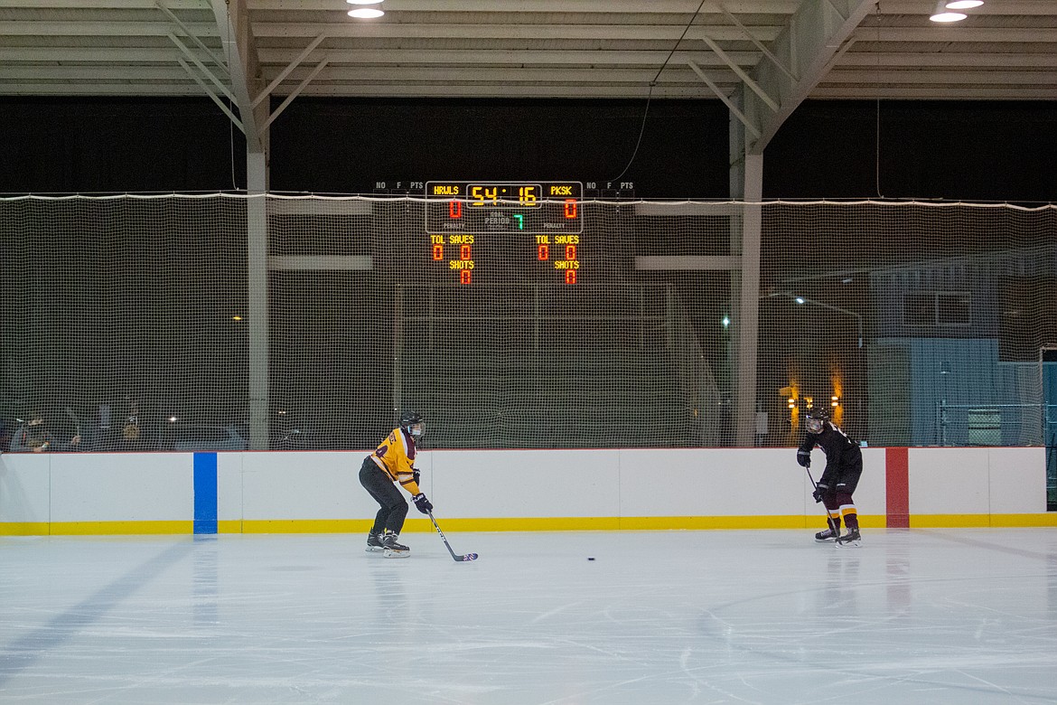 Left to right, Jordan Cohee and Josh Hopkins with the Moses Lake Coyotes 18U team make their way around the ice at the rink in Moses Lake on Monday evening as the team warms up for practice.