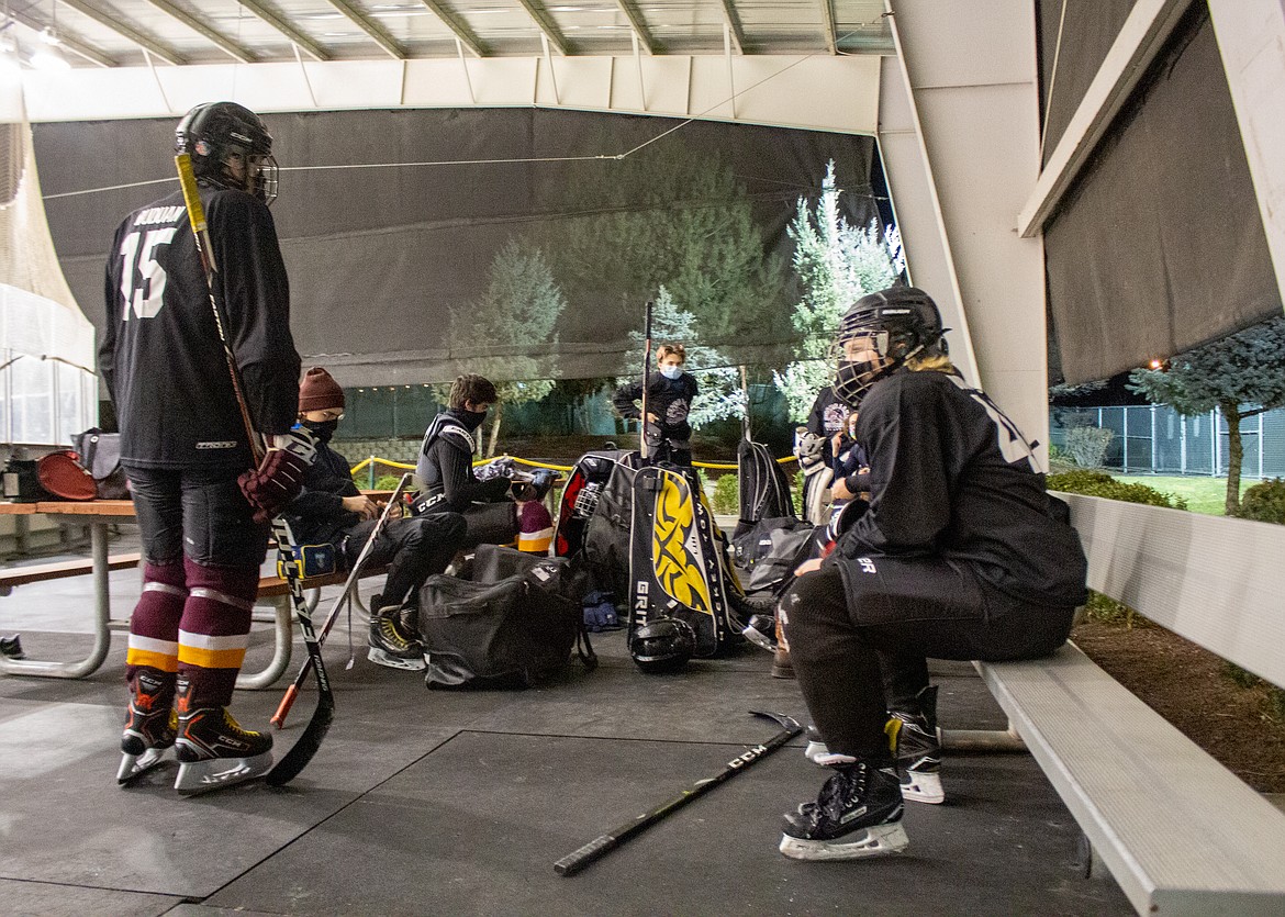 Front left to right,Noah Burns and Brayden Buduan get geared up with their teammates before practice Monday night at the Moses Lake Ice Rink.