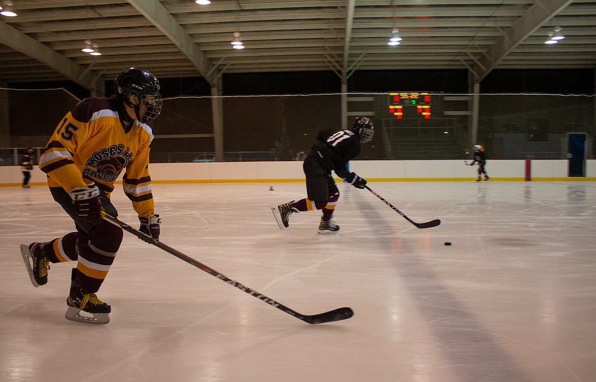 Left to right, Brayden Buduan and Carson Shurtz float down the ice during a passing drill to kick things off for the 18U team at the ice rink in Moses Lake on Monday night.