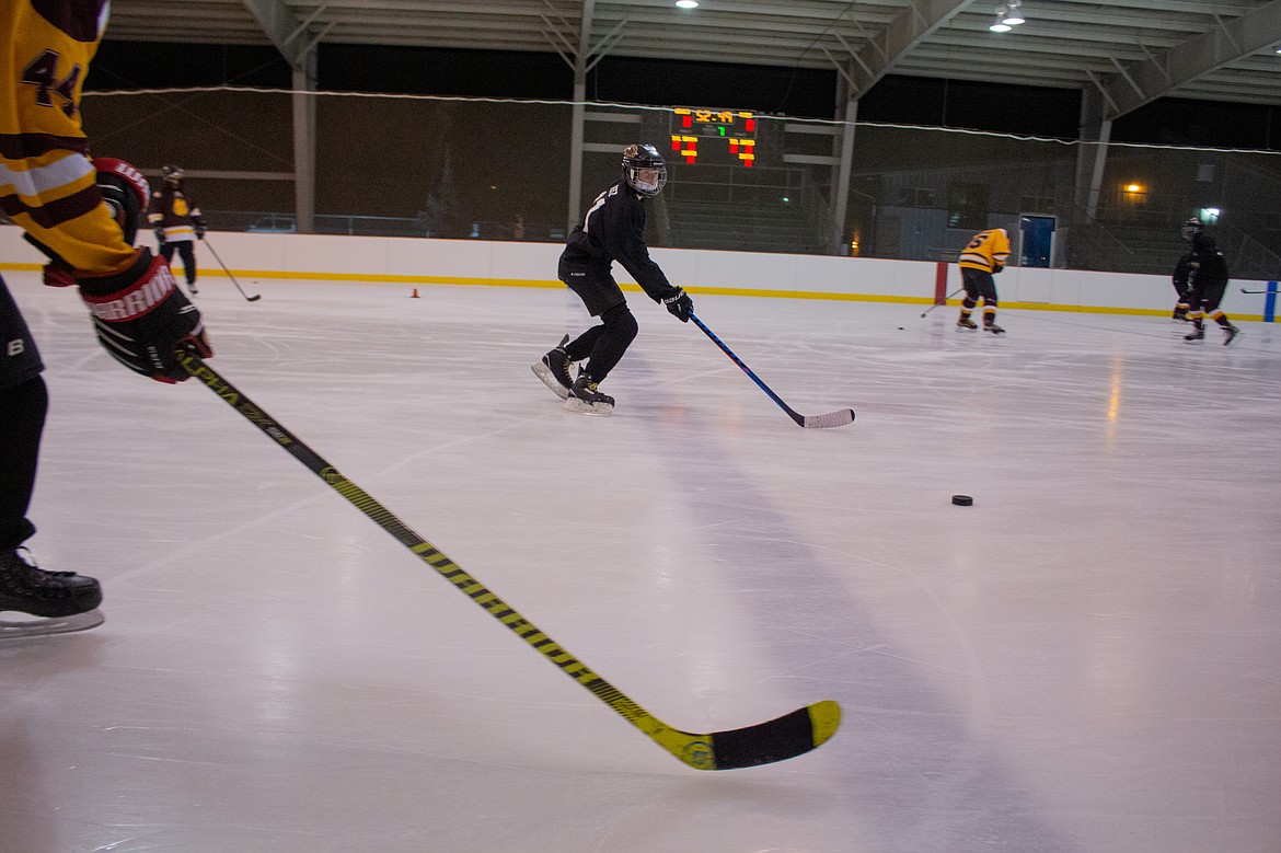 Nolan Betz eyes in the pass during a drill at the beginning of practice for the 18U Moses Lake Hockey team on Monday evening.