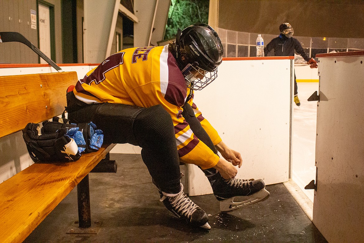 Jordan Cohee adjusts his skate during practice on Monday night at the ice rink in Moses Lake.