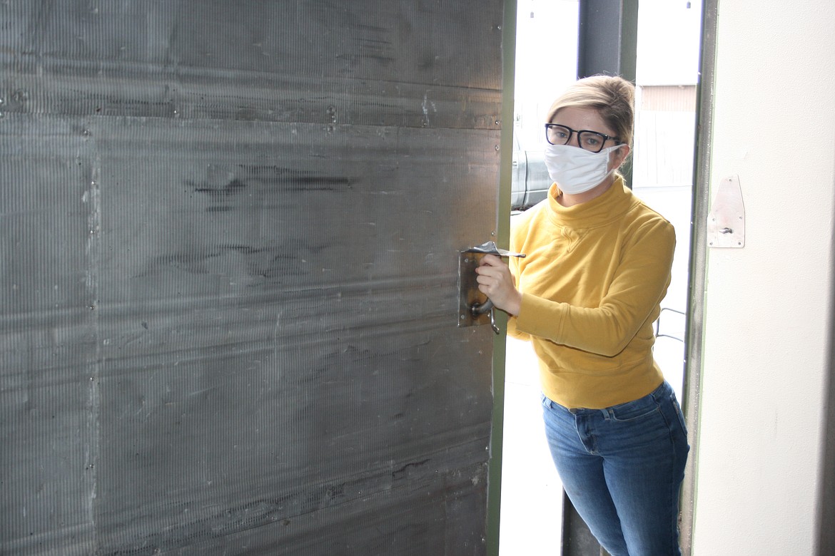 Erika Rattray, owner of the Ironworks Cafe in Othello, opens the oversize door that has allowed the restaurant to reopen for inside dining.