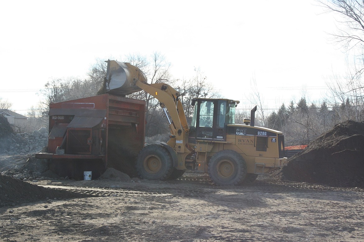 A loader fills a dirt sifting machine at the site of a wetland under construction in Moses Lake. Building a wetland, at least this wetland, starts with moving a lot of dirt.