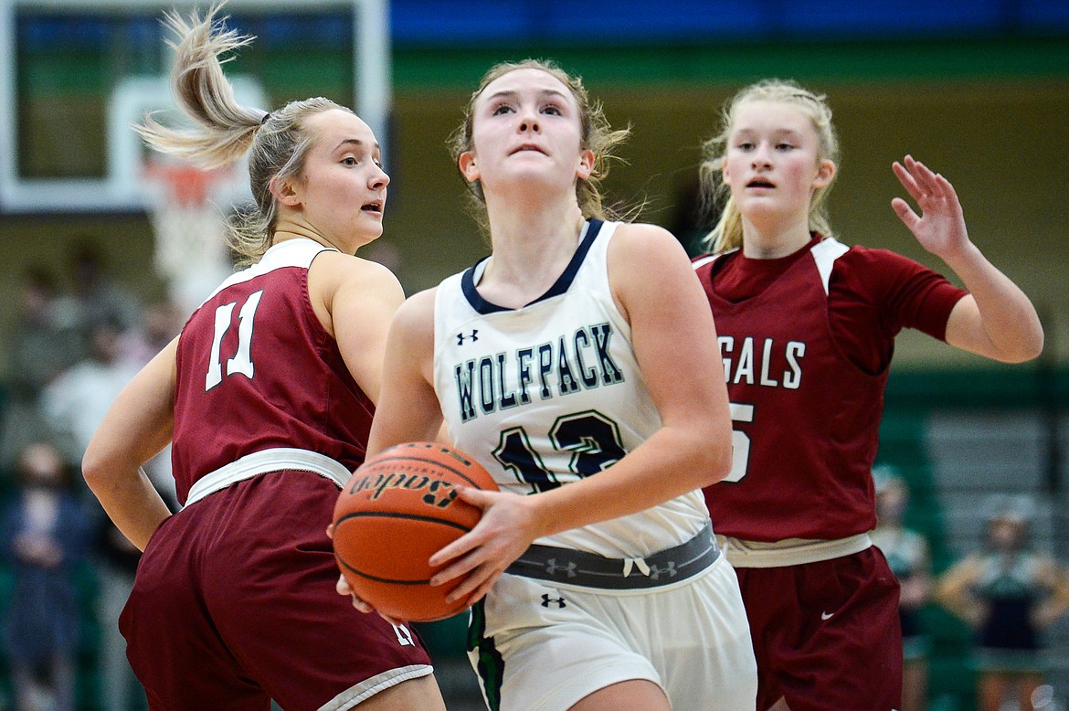 Glacier's Kenzie Williams (12) drives to the basket past Helena's Brooke Ark (11) and Avery Kraft (15)  at Glacier High School on Thursday. (Casey Kreider/Daily Inter Lake)