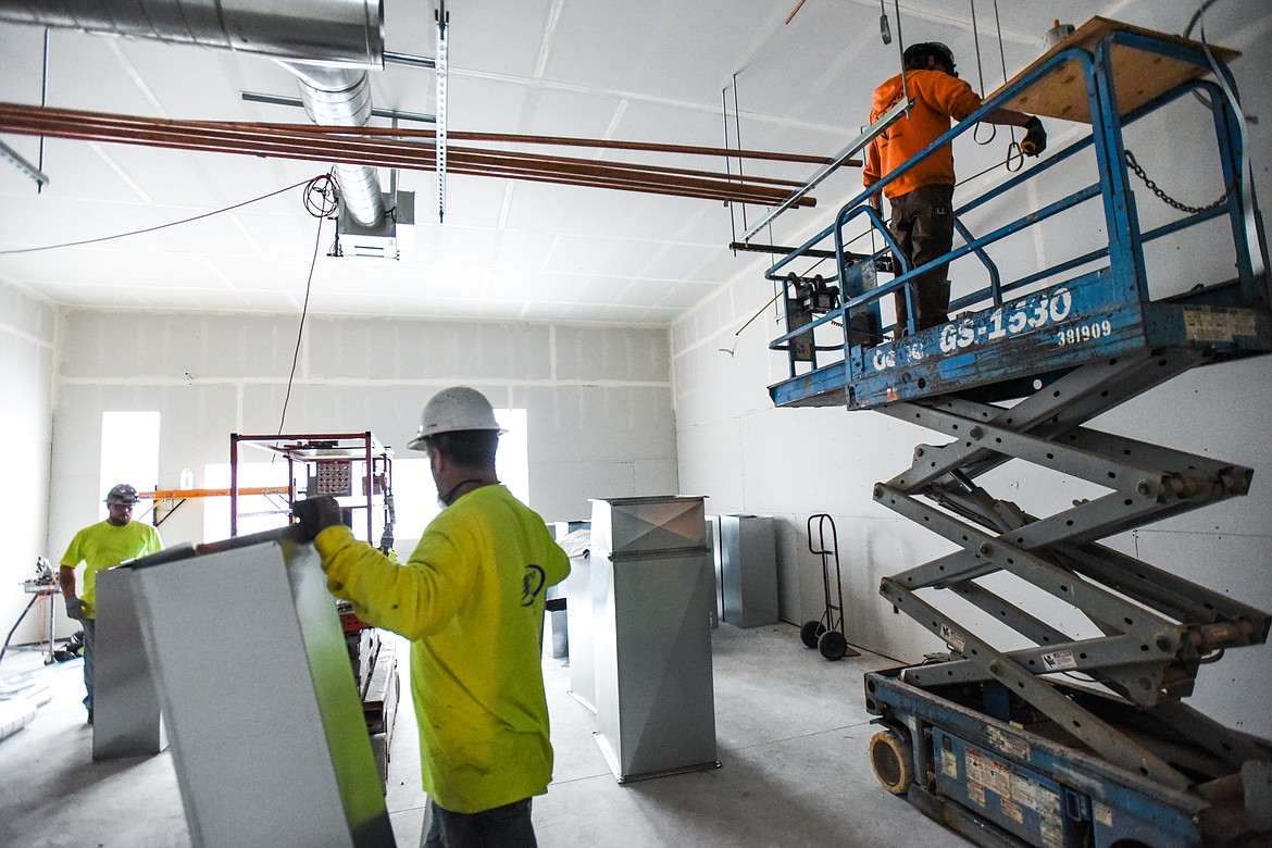 Workers carry in ductwork to install in a classroom at Ruder Elementary School in Columbia Falls on Tuesday, Jan. 26. (Casey Kreider/Daily Inter Lake)