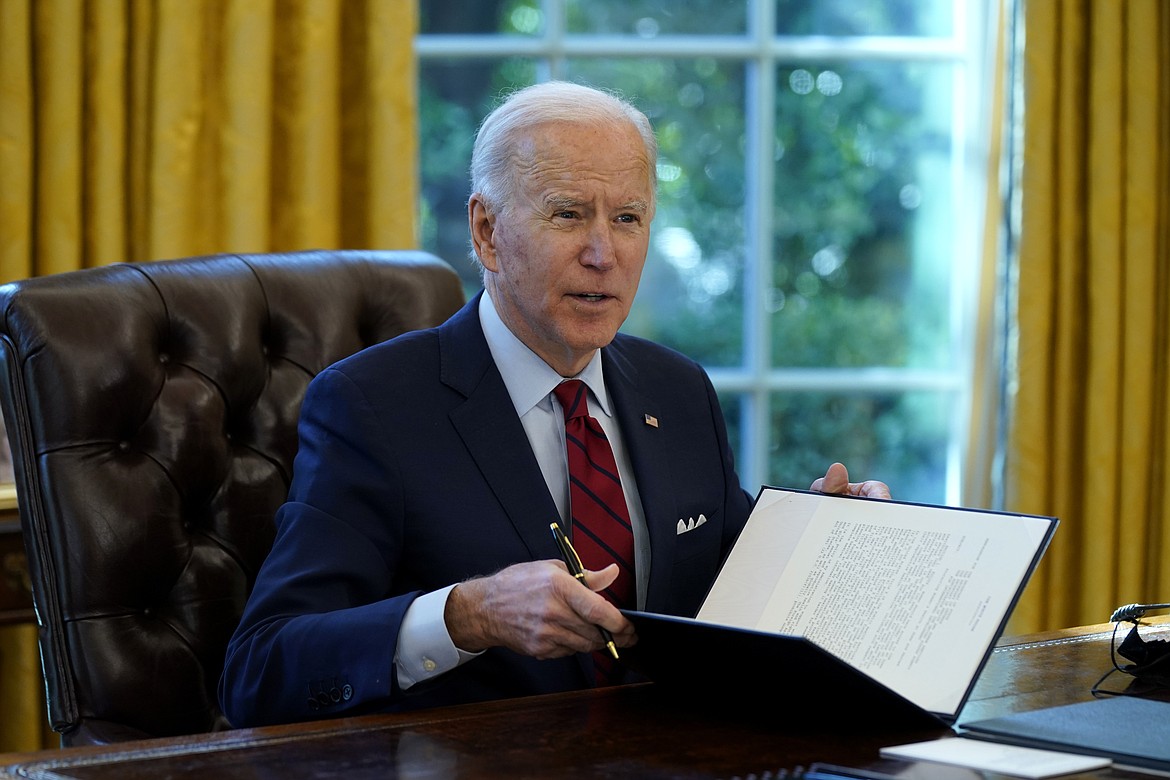 President Joe Biden signs a series of executive orders on health care, in the Oval Office of the White House, Thursday, Jan. 28, 2021, in Washington.