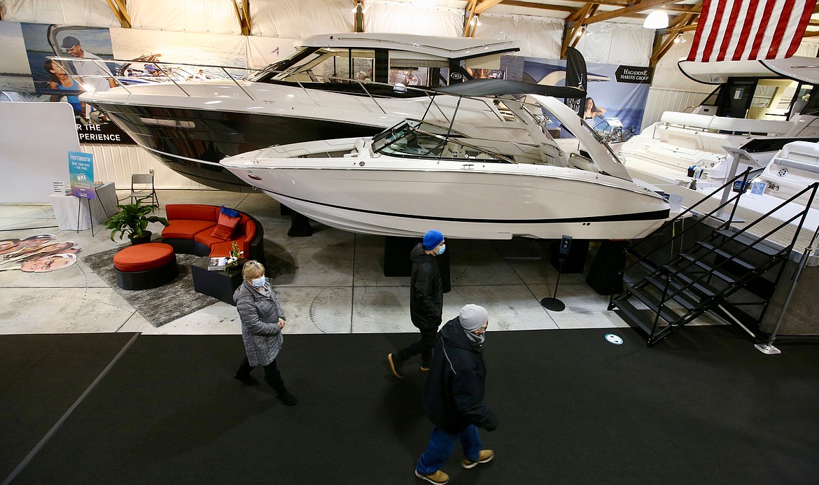 Visitors to the Coeur d'Alene Boat Expo walk past boats on display Thursday at the Hagadone Marine Center.