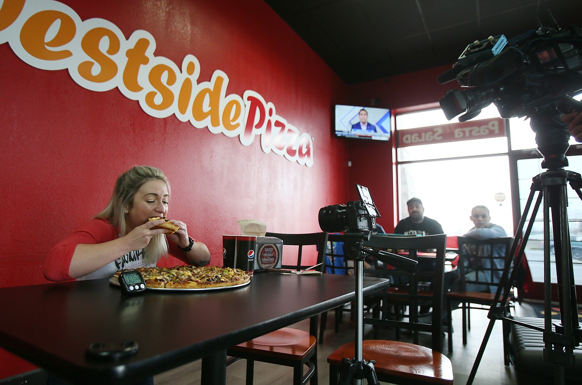 Food challenge YouTuber "Katina Eats Kilos" Katina DeJarnett takes a bite of her first slice in the Death by Pizza Challenge on Thursday. She and boyfriend Randy Santel were the first to rise to the challenge at the Post Falls store, both completing the 18-inch, 10-topping pizza and winning cash and bragging rights.