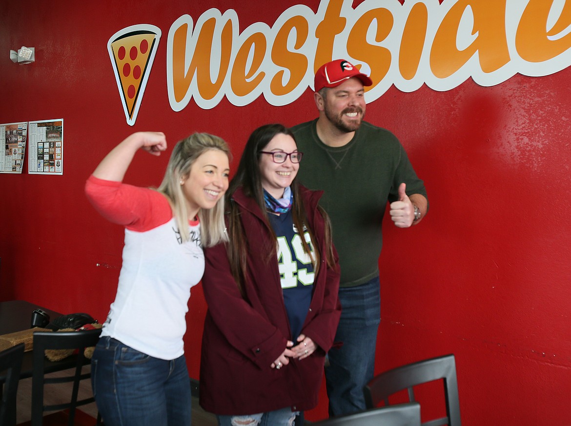 Fan Brandi Atchison, center, smiles for the camera with famous food challengers Katina DeJarnett and Randy Santel during their Death by Pizza Challenge at Westside Pizza on Thursday.