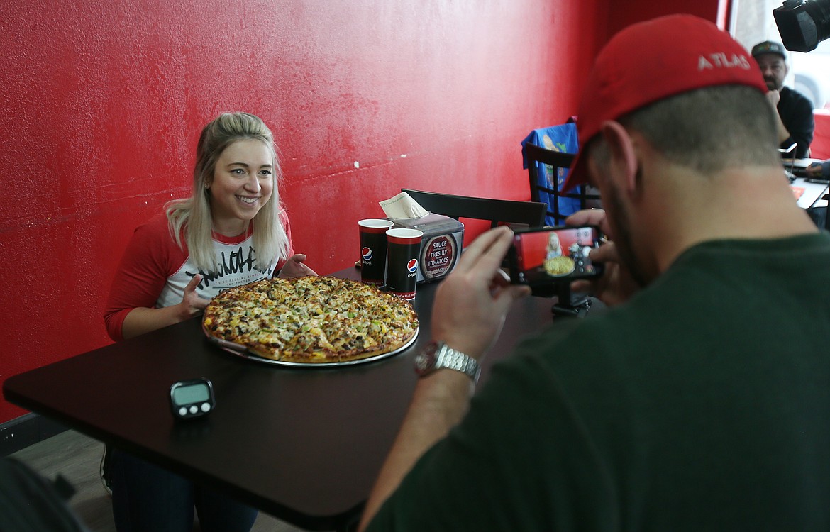 Katina DeJarnett of "Katina Eats Kilos" YouTube fame films an intro with boyfriend and professional eating colleague Randy Santel in Westside Pizza on Thursday. Both completed the Death by Pizza Challenge by eating an 18-inch Death by Pizza pie in less than an hour.