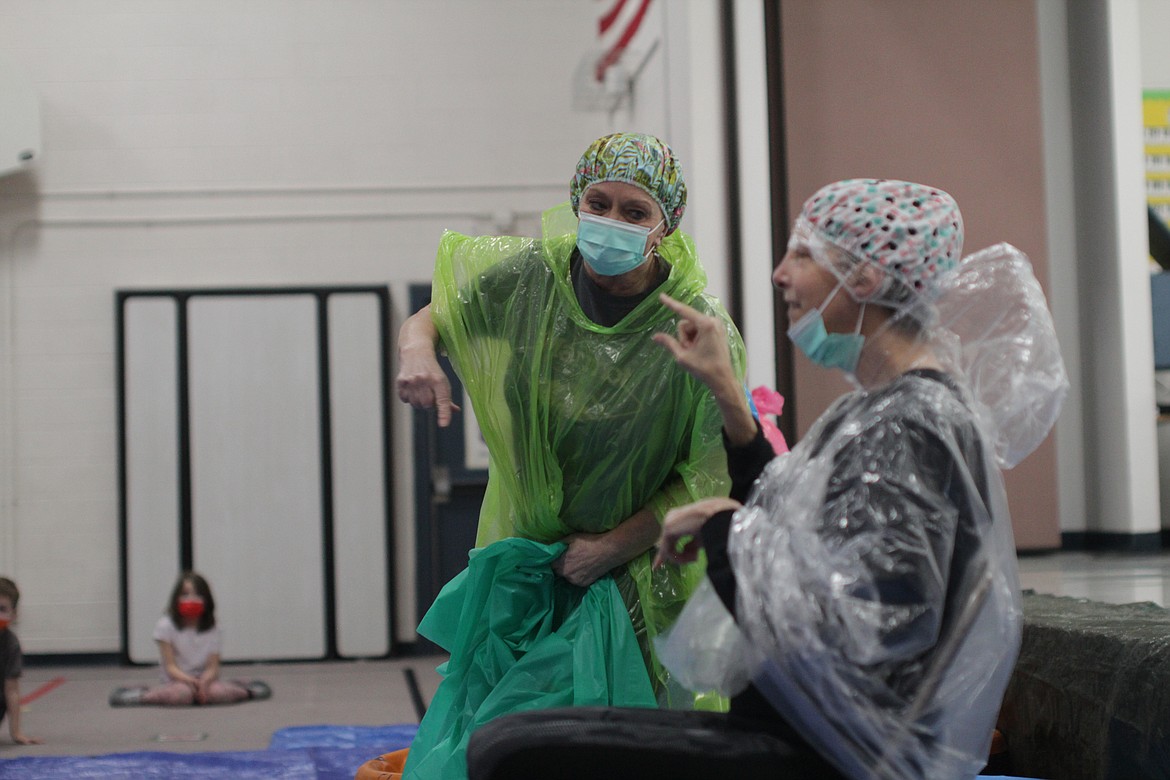 Wilma Hahn and Susie Luckey point at each other as students prepare to dump slime on them Thursday afternoon at Idaho Hill Elementary School.