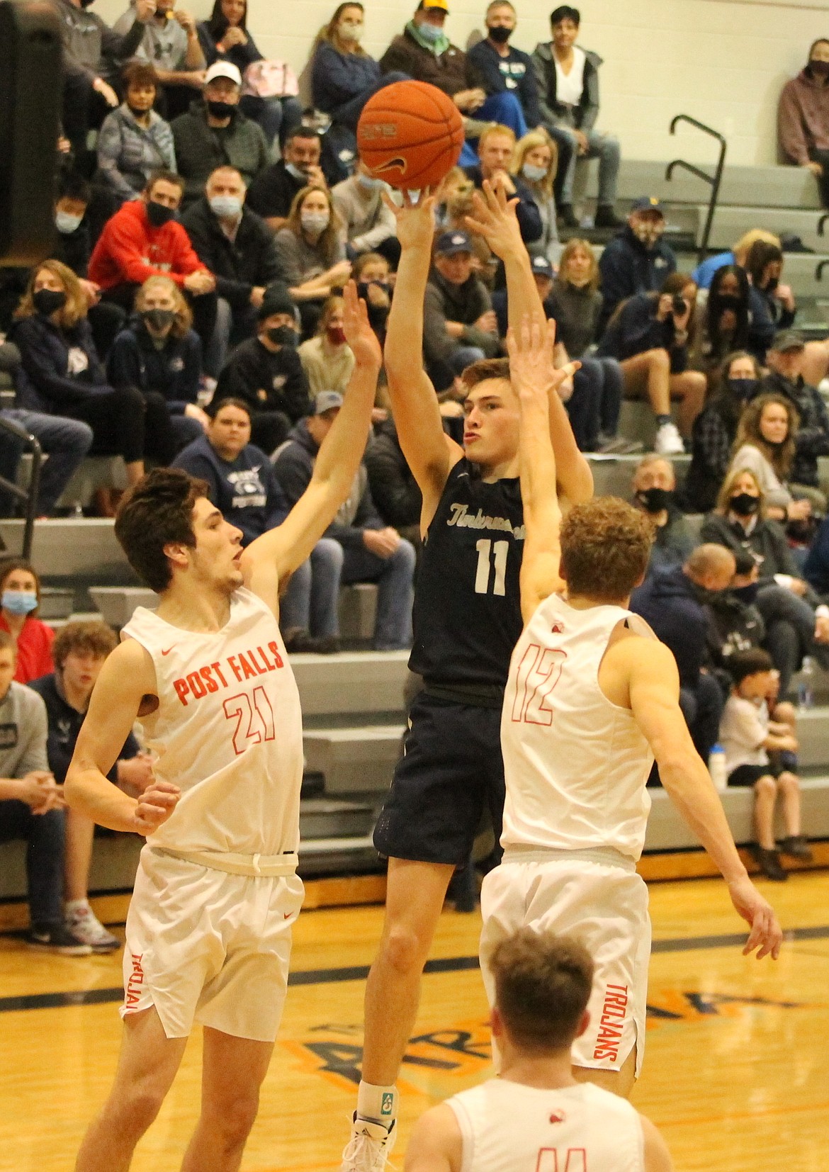 MARK NELKE/Press
Zach Johnson (11) of Lake City shoots as James Lee (21) and Isaac Ballew (12) of Post Falls defend Thursday night in Post Falls.