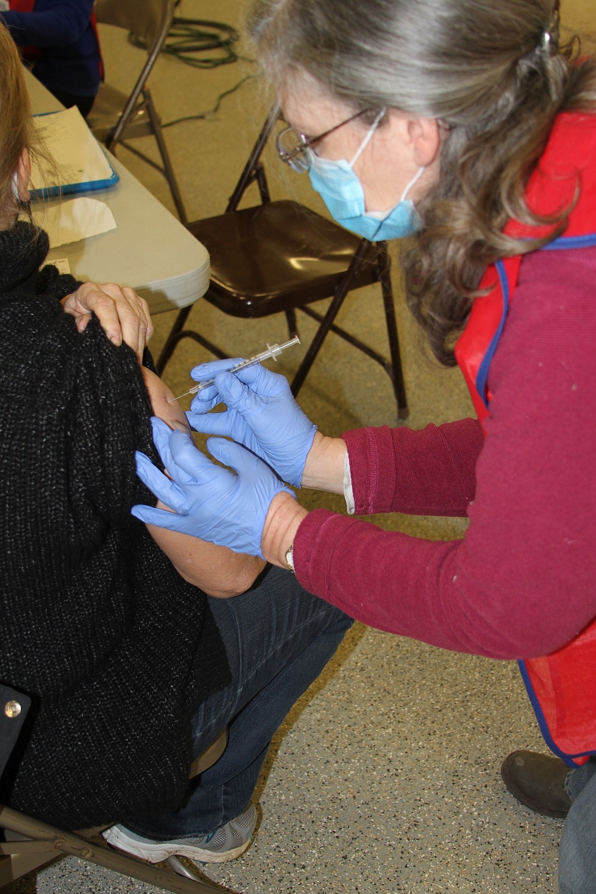 Carole Thorell, a licensed practical nurse with the North Idaho Medical Reserve Corps, administers a second dose of the COVID-19 vaccination at the Bonner County Fairgrounds in early 2021.