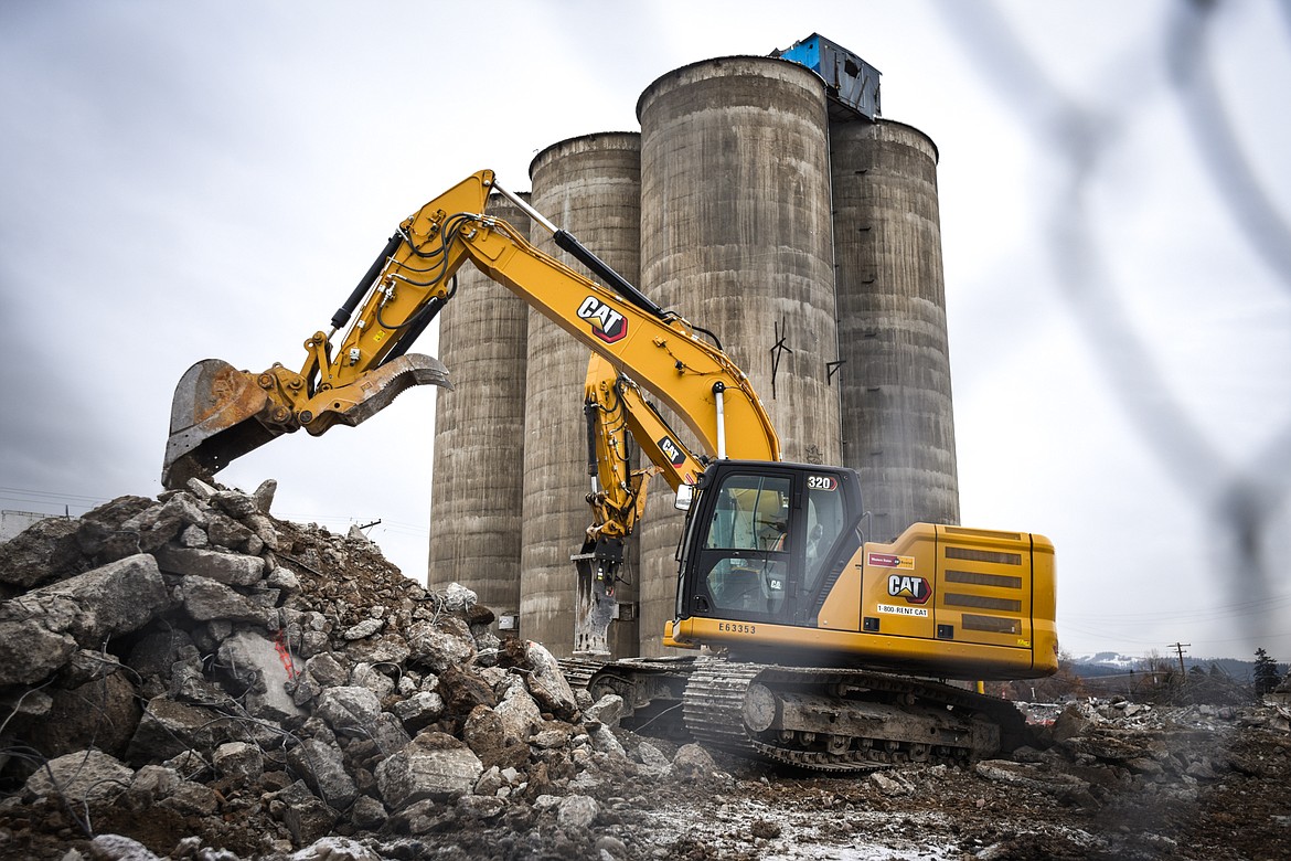 Workers with Olympus Technical Services, of Helena, break up concrete and clear debris from the former CHS site along West Center Street in Kalispell on Friday, Jan. 15. The site, now owned by the Flathead County Economic Development Authority, is being completely cleared except for the six former grain elevators to spur development along the future Kalispell Parkline Trail. The structure atop the grain elevators, which was recently painted by local artist Thomas Valencia, is also being removed. (Casey Kreider/Daily Inter Lake)