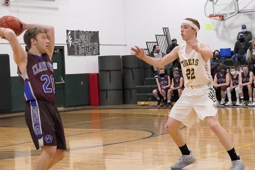 Clark Fork's Bryan Mask, left, looks to pass around St. Regis forward Tanner Day during Saturday night's game. (Chuck Bandel/Mineral Independent)