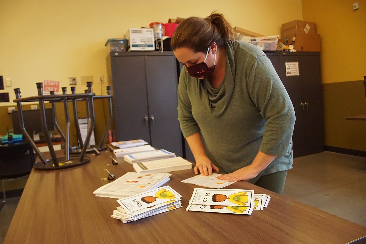 Boys & Girls Club director of programs Rebecca Mabius folds pamphlets for the PAX Kits on Friday.