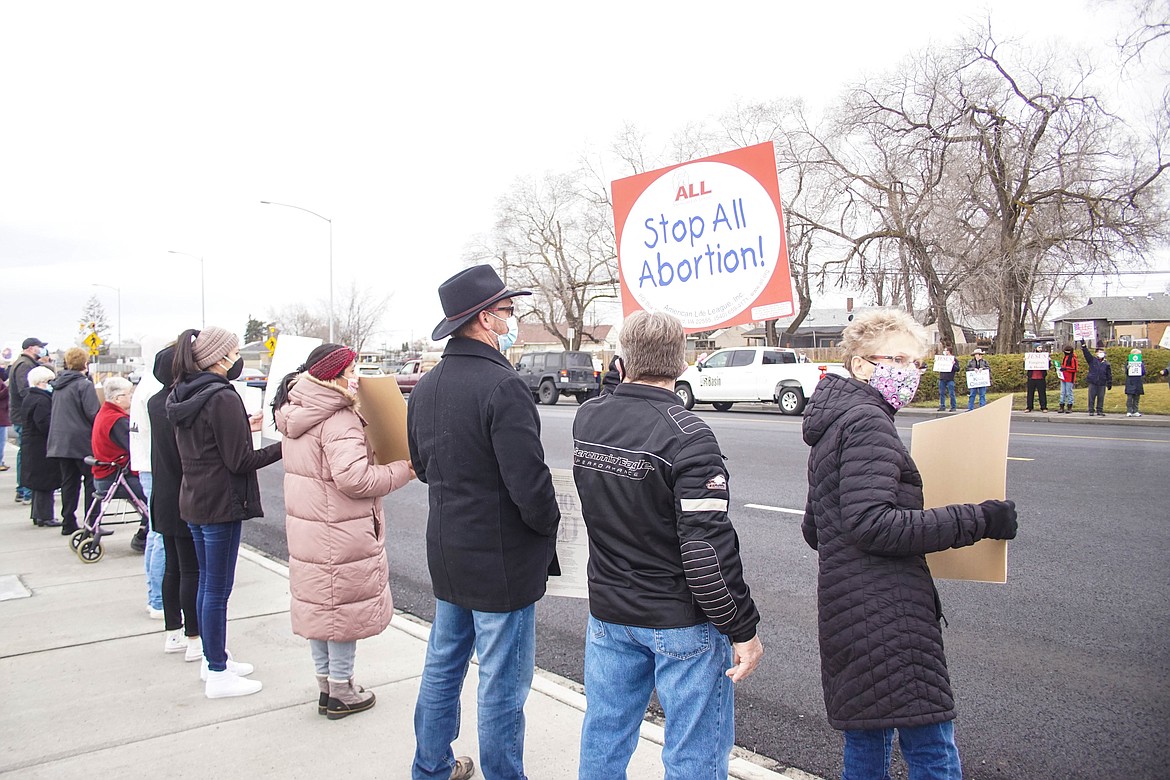 Moses Lake resident Dave Oliver holds the red sign at a pro life rally on Sunday.