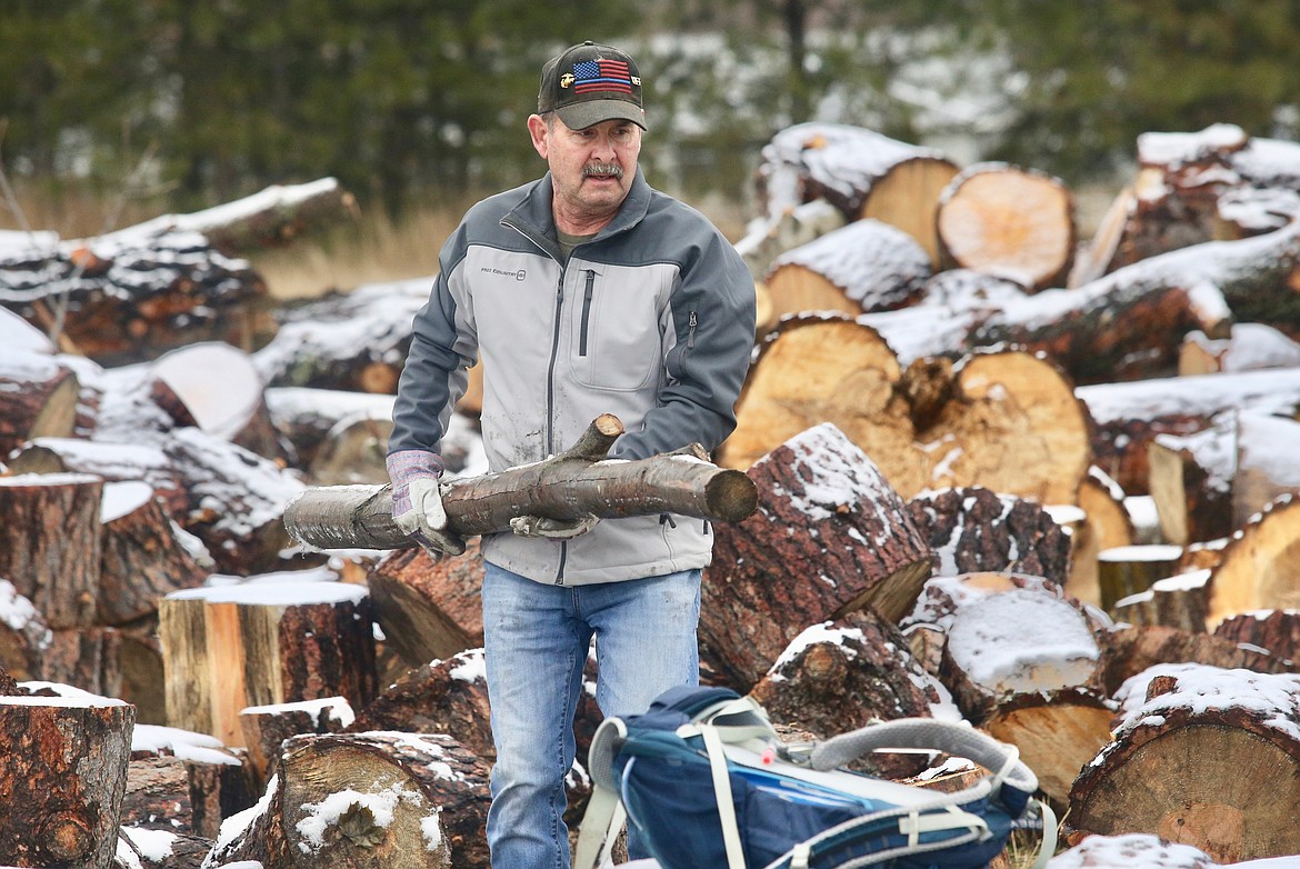 Wade Gaub carries a wood on Saturday as volunteers with ElderHelp to prepare free firewood for seniors.