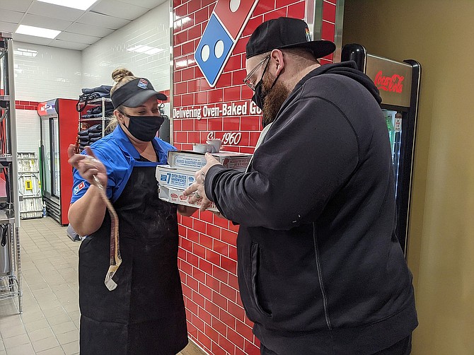 Shoshone News-Press staff reporter Josh McDonald picks up the first official order from the newly opened Domino's in Kellogg.