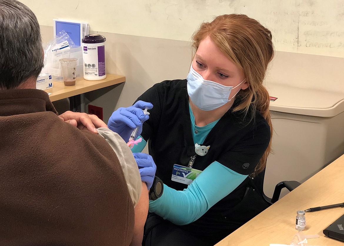 Haley Williams, registered nurse for Kootenai Health's Emergency Services, administers a COVID-19 vaccine Monday. Idahoans 65-and-older now qualify for the vaccine, but booked-up online reservations through the hospital and jammed phone lines through Kootenai Health have local officials asking for patience. (Courtesy of Kootenai Health)