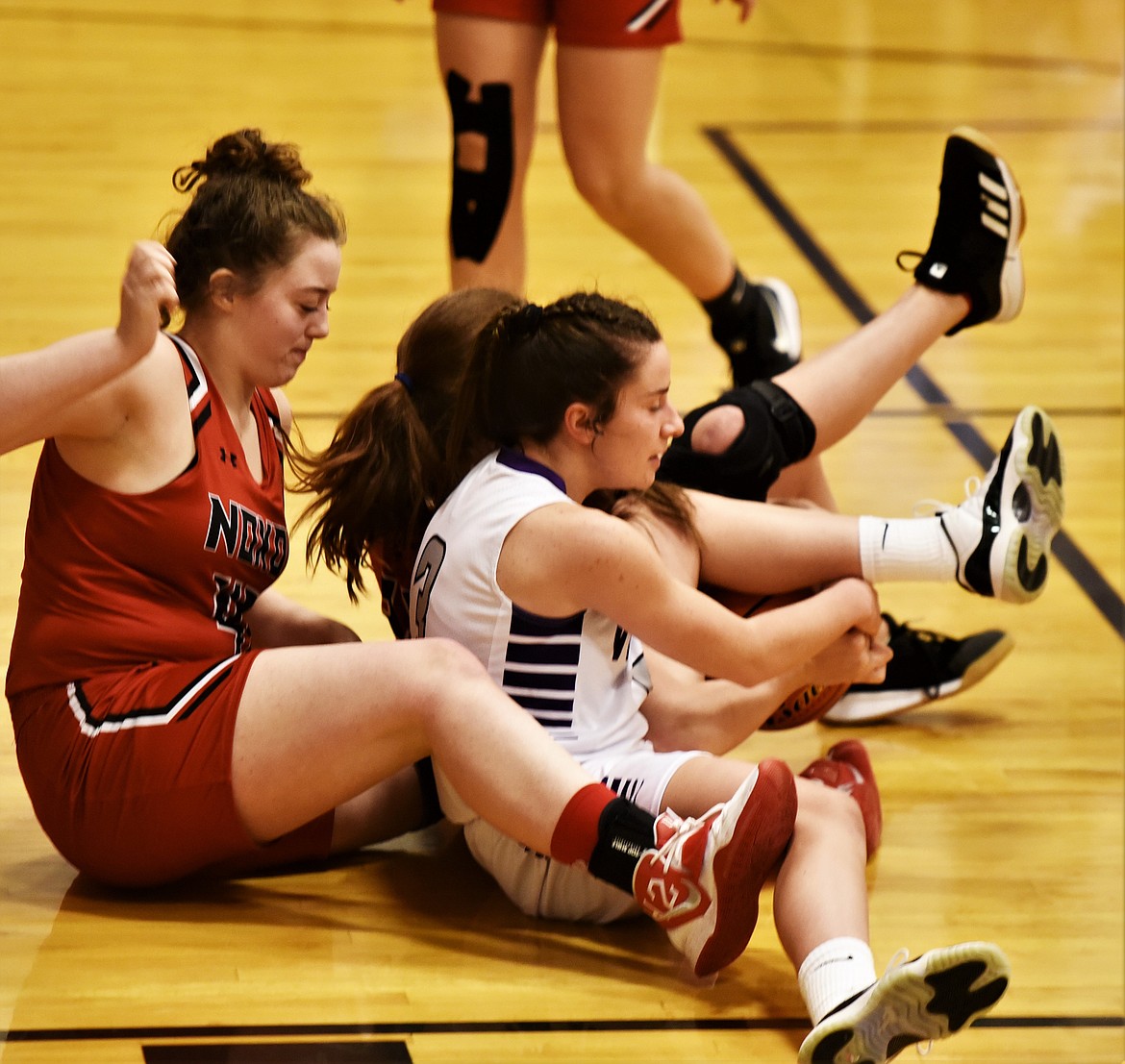 Charlo's Hayleigh Smith battles for a loose ball with Noxon players, including Vanessa Horner, left. (Scot Heisel/Lake County Leader)