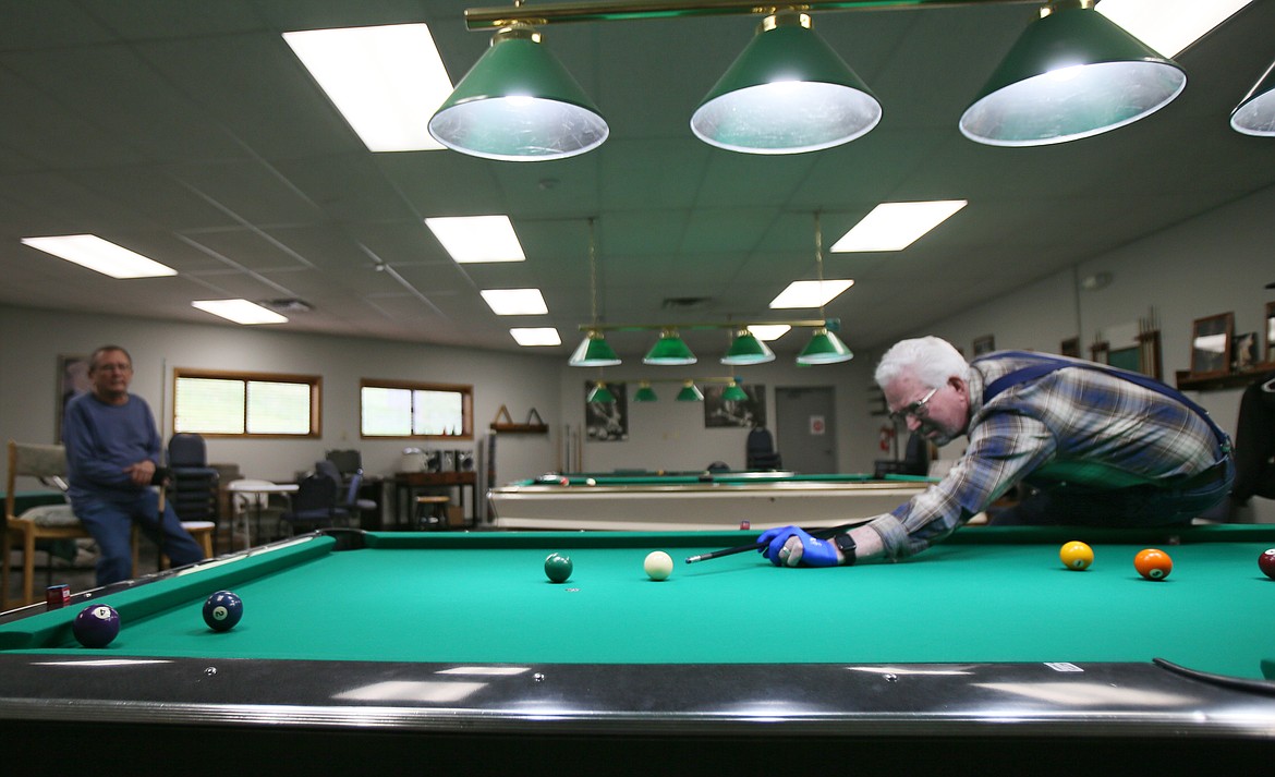 Mike Austin of Hayden lines up a pool shot Thursday in Lake City Center's billiard room with friend Ron Davis of Post Falls. The center will be returning to somewhat normal as congregate meals resume Monday. Drop-off Tax-Aide help will be available by appointment beginning March 1 and an open house is set for March 2.