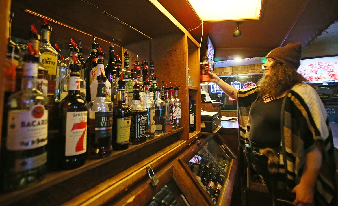 Lakers Inn bartender Jaki Whitmore replaces a bottle on the shelf on Thursday evening. Whitmore, who has been a bartender in Coeur d'Alene for nearly 10 years, said she has "absolutely, 100%" seen an increase in alcohol consumption among patrons and throughout the community in the past year.