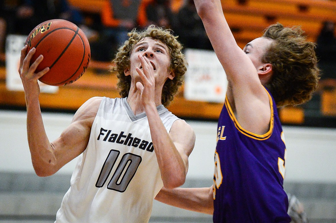 Flathead's Hunter Hickey (10) drives to the basket against Missoula Sentinel's Kaden Sheridan (30) at Flathead High School on Saturday. (Casey Kreider/Daily Inter Lake)