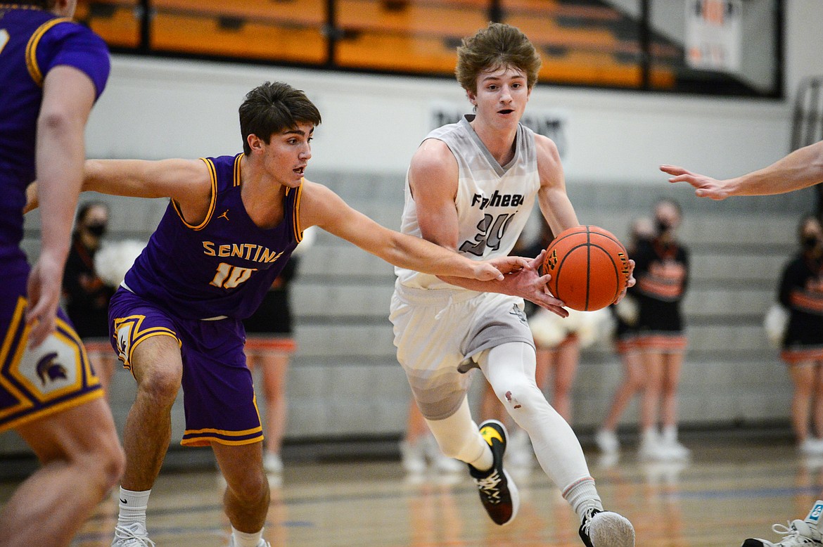 Flathead's Joston Cripe (34) drives into the lane guarded by Missoula Sentinel's Soren Syvrud (10) at Flathead High School on Saturday. (Casey Kreider/Daily Inter Lake)