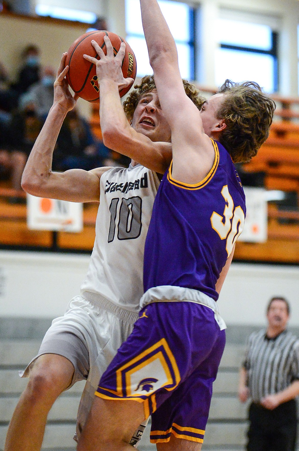 Flathead's Hunter Hickey (10) draws a foul on his way to the basket against Missoula Sentinel's Kaden Sheridan (30) at Flathead High School on Saturday. (Casey Kreider/Daily Inter Lake)