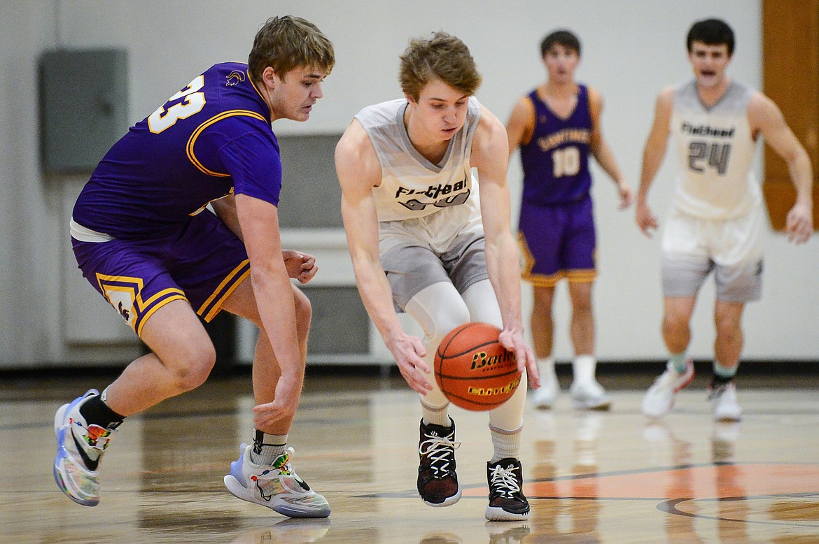 Flathead's Joston Cripe  (34) scoops up a steal from Missoula Sentinel's Hayden Kolb (23) at Flathead High School on Saturday. (Casey Kreider/Daily Inter Lake)