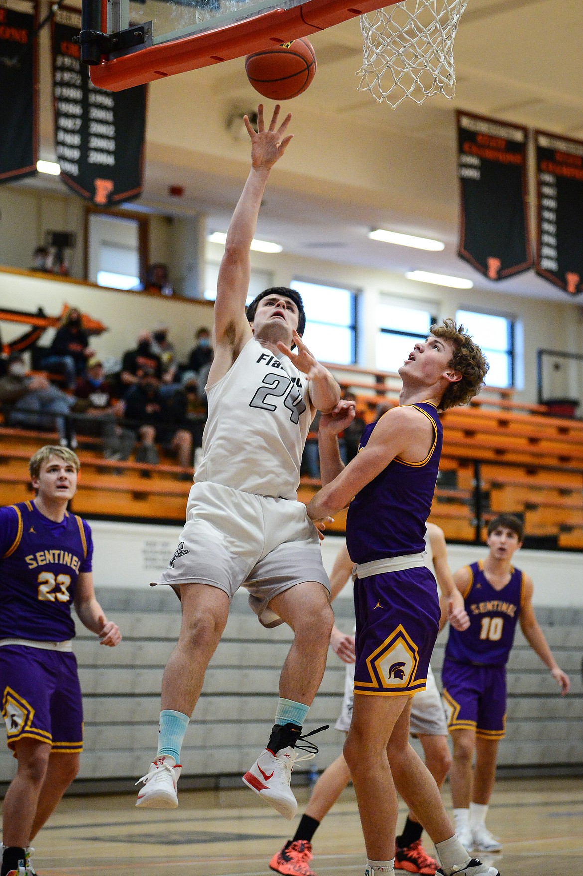 Flathead's Gabe Adams (24) gets to the hoop against Missoula Sentinel's Alex Germer (5) at Flathead High School on Saturday. (Casey Kreider/Daily Inter Lake)